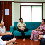 **

A group discussion among Malaysian social workers. Focus on a social worker facilitating a discussion among family members during a counseling session in a modern Malaysian home, promoting communication and conflict resolution.

**